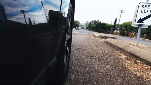 Car POV from road facing front right wheel driving down bitumen road down Stock Footage 101723039