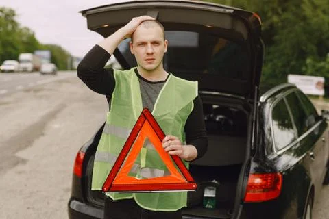 Car with problems and a red triangle to warn other road users Stock Photos