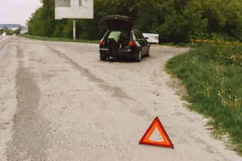Car with problems and a red triangle to warn other road users Stock Photos