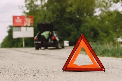 Car with problems and a red triangle to warn other road users Stock Photos