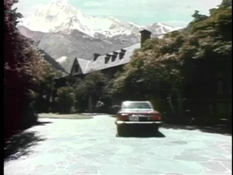 Car pulling up in front of house in snow capped mountains Stock-Footage 260254795