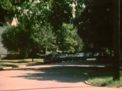 Car pulling up in front of house in the suburbs, 1980 Stock Footage 61766862