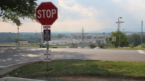 Car pulling up to a stop sign on a college campus Stock Footage 53200689