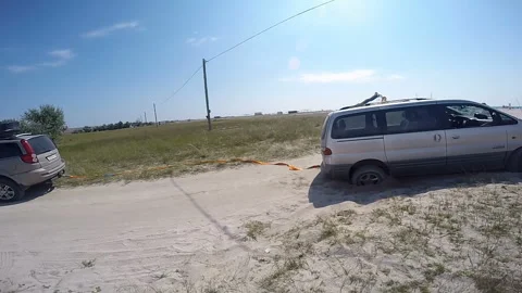 Car pulls another car out of the sand Video stock 102087549