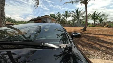 Car pulls out from under wooden carport turning onto road Stock Footage 307484404