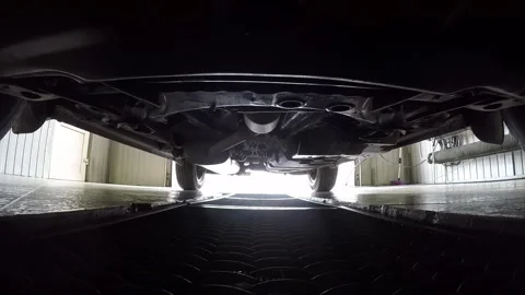 Car pulls parking into garage on metal grid, view on bottom of car. Stock Footage 257078030