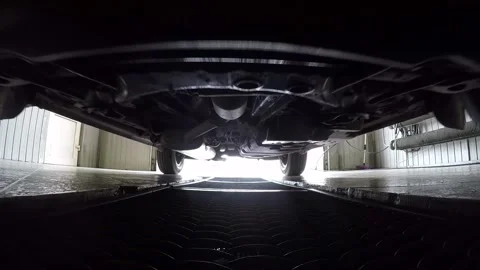 Car pulls parking into garage on metal grid, view on bottom of car. Stock Footage 257078065