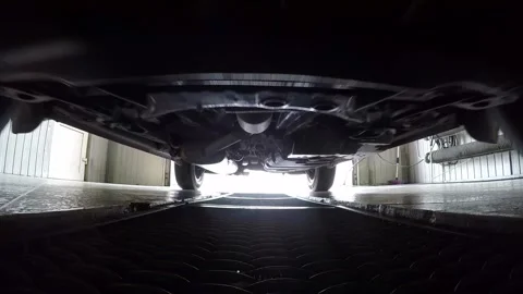 Car pulls parking into garage on metal grid, view on bottom of car. Stock Footage 257078092