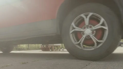 The car pulls into the parking lot. Close-up on spinning wheels Stock Footage 258678149