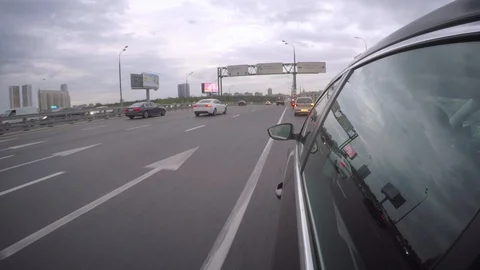 A car pulls off a wide highway in the direction of office skyscrapers. Side view Stock Footage 100434275