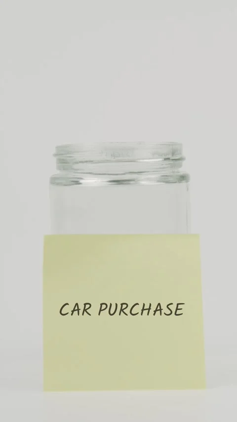 Car purchase text or word on yellow sticky note attached to glass jar Stock Footage 311688489