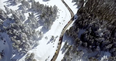 Car queue parked on the side of road through snow and fir tree forest Stock Footage 104655240