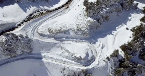 Car queue parked on the side of road through snow and fir tree forest Stock Footage 104655353