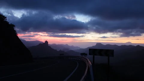Car races down mountain road at dusk Stock Footage 141606796