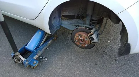 Car raised on jack. Changing flat tire on your own. Wheel replacement. Stock Photos