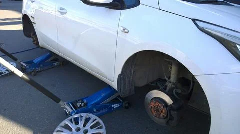 Car raised on jack. Changing flat tire on your own. Wheel replacement. Stock Photos
