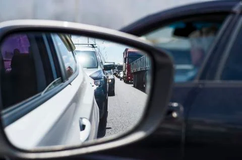 Car rear view mirror with reflection of the traffic flow in the tube. Concept Stock Photos
