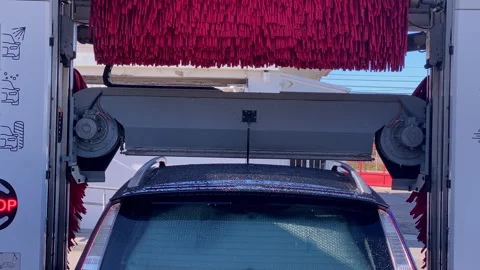Car receiving automatic cleaning service in a car wash Stock Footage 333036913