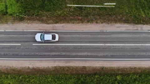 Car with reflected blue sky in windshield drives along road Stock Footage 132814264