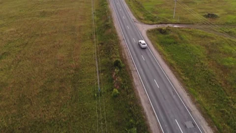 Car with reflected blue sky in windshield drives along road Stock Footage 132814687