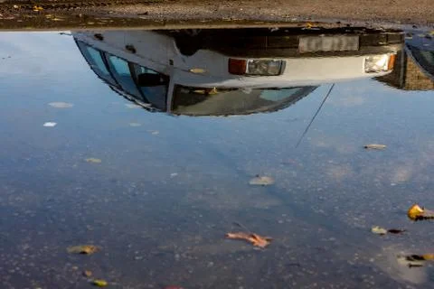 Car reflected in puddle Stock Photos