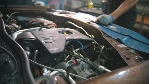 Car repair shop - working engine under the car hood Stock Footage 128171643