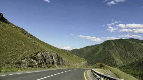 A car ride on the background of a mountainous area. The car is driving road. Stock-Footage 221994231
