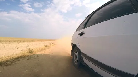 The car rides in the desert. View from the right side to a back wheel Stock Footage 123947369
