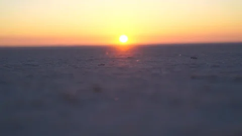 Car rides on a flat sandy surface against the background of dawn Stock Footage 122454494