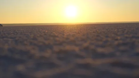 Car rides on a flat sandy surface against the background of dawn Stock Footage 122454534