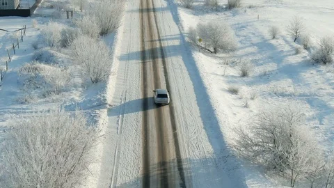 Car rides by road in snow-covered forest. Aerial view of a snowy forest with Stock Footage 120983377