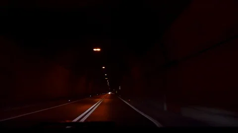 A car rides through a dark night car tunnel in Europe, Croatia. Ahead appears Stock Footage 124477258