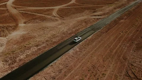 Car rides through the desert on an empty deserted highway to the sea. Aerial Stock Footage 131145076