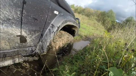 The car rides through the mud on the descent to the river. Off-road. Stock Footage 68041011