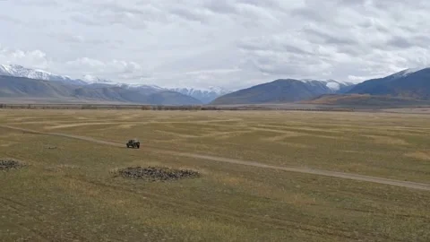 Car riding on sandy road in mountainous valley Stock Footage 154412237