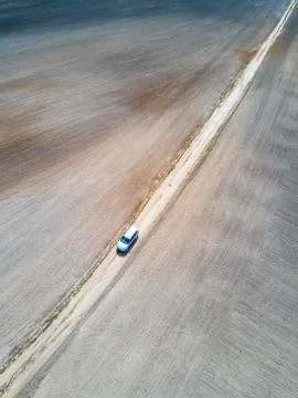 Car road between plowed fields, aerial view. Stock Photos