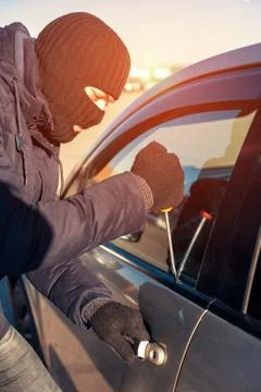 Car robber breaking into auto using screwdriver Stock Photos
