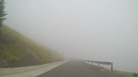 Car running high speed time lapse on bad visibility along mountain road on fo Stock Footage 86218635