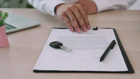 Car sales representative submits the contract documents for the customer to s Stock Footage 164158750