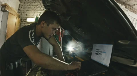 Car service, computer diagnostics: mechanic repairs the damage using the pc Vídeos de archivo 64859807