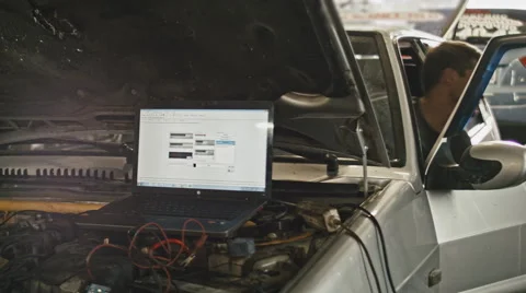 Car service, computer diagnostics: mechanic repairs the damage using the pc Vídeos de archivo 64860170