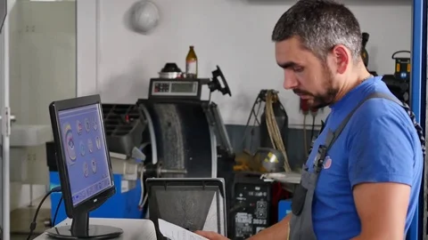 Car service, computer diagnostics: mechanic repairs the damage using the pc in Vídeos de archivo 80460162