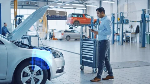Car Service Manager Uses a Tablet Computer with a Futuristic Augmented Reality Stock Footage 128854441