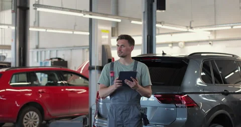 Car service manager uses a tablet computer with an diagnostics software. Vídeo Stock 341869628