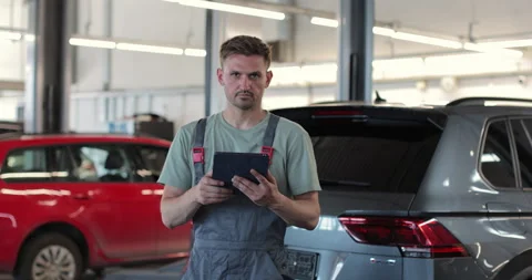 Car service manager uses a tablet computer with an diagnostics software. Vídeo Stock 341869783
