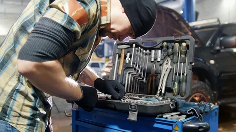 Car service. Mechanic man choosing a tool in the case Stock Footage 101693477
