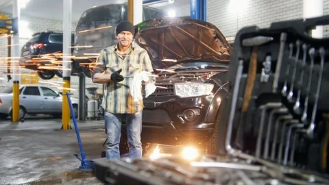 Car service. Mechanic man standing by the car and wipes off the tool Stock Footage 101688484