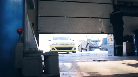 Car service work - yellow car drives to garage at sunny winter day Stock Footage 73384641