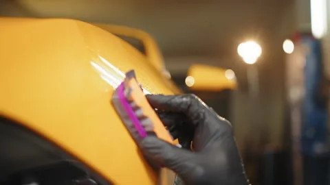 Car service worker applying nano coating on a car detail. Stock Footage 233910659