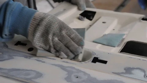 In a car service, a worker puts putty on a part Stock Footage 120081255
